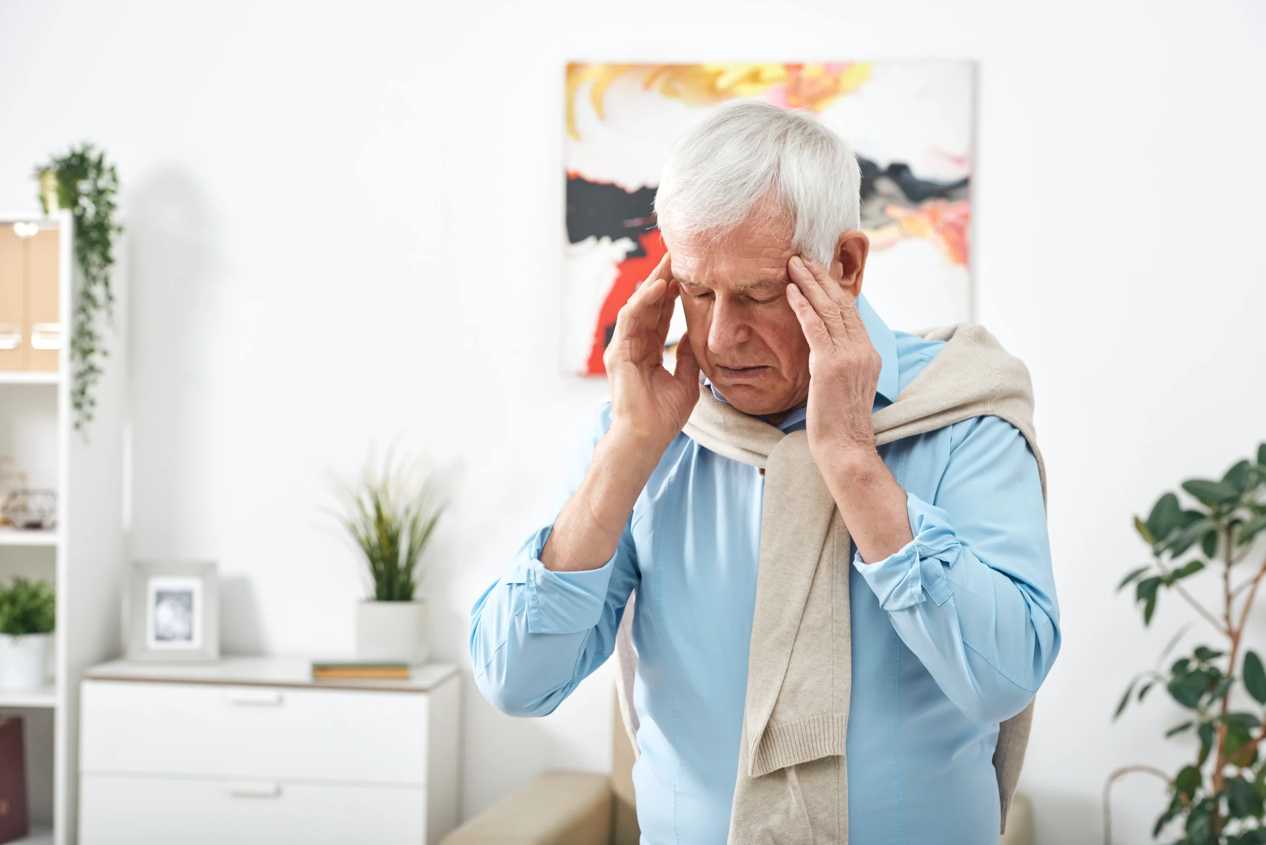 tired-senior-man-blue-shirt-touching-his-temples-while-feeling-headache-after-working-home